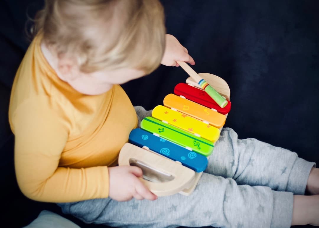 Child playing with a colorful musical toy